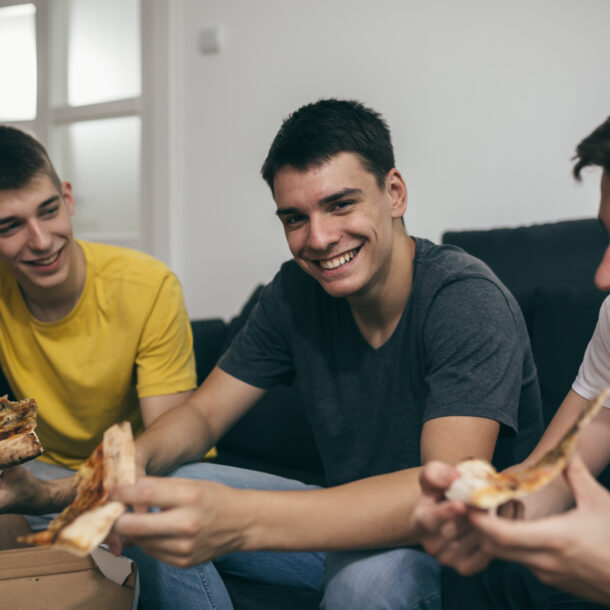 Teen boys eating pizza